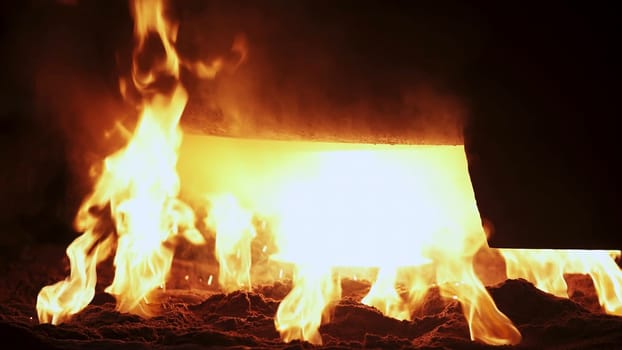 In an incredibly intense industrial scene, flames erupt and molten metal flows dramatically, creating a vivid display. Stock Clip