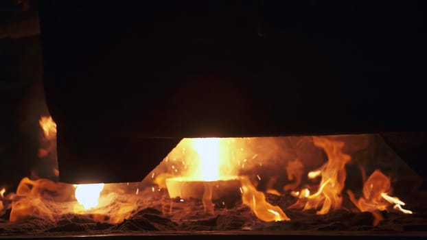 Intense liquid molten metal is being poured, showcasing vivid flames and the glowing heat emitted from it. Stock Clip