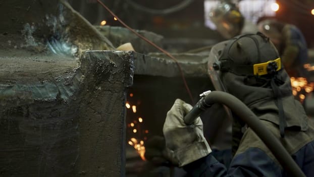 Dedicated workers are engaged in welding, skillfully creating vibrant sparks in a busy industrial environment. Stock Clip