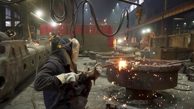 Numerous workers diligently engaging in metal fabrication and welding processes within a bustling industrial setting. Stock Clip