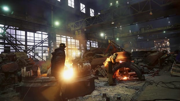 A bustling foundry with molten metal, hardworking workers, and surrounded by industrial equipment and tools. Stock Clip