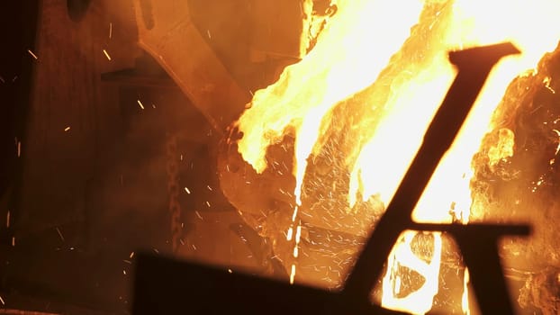 A captivating scene unfolds in the metalworking shop, with bright sparks flying around a hot, glowing furnace. Stock Clip