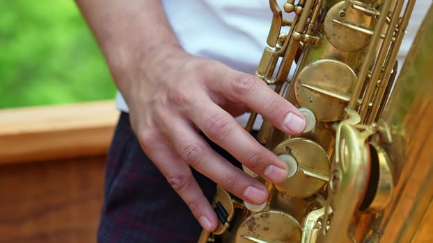 An intricate and detailed view of a hand expertly positioned on a saxophone, showcasing musical artistry and talent. Clip
