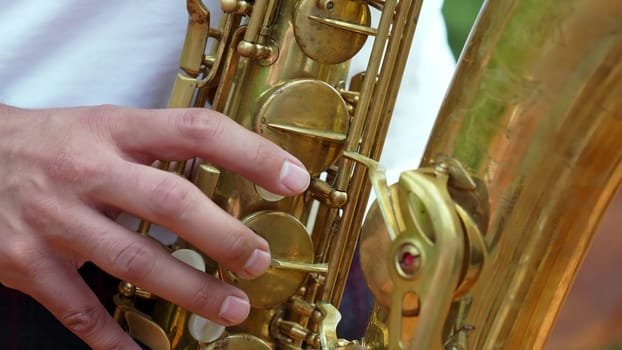 An intricate and detailed view of a hand expertly positioned on a saxophone, showcasing musical artistry and talent. Clip