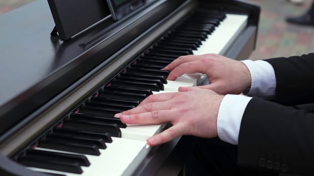 A close-up of hands playing a digital piano, capturing the artistry and elegance of music performance. Clip