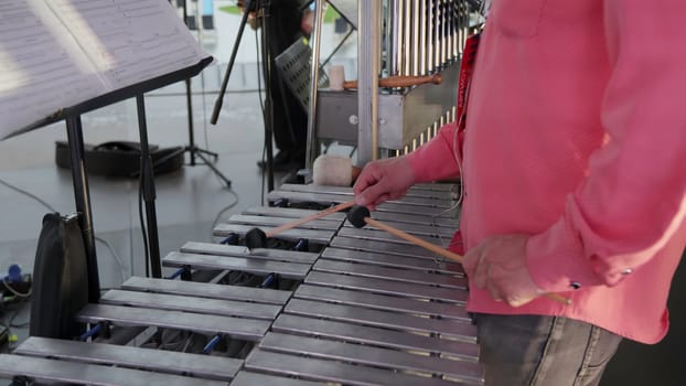 A skilled musician passionately plays a xylophone during an engaging outdoor performance event for everyone. Clip