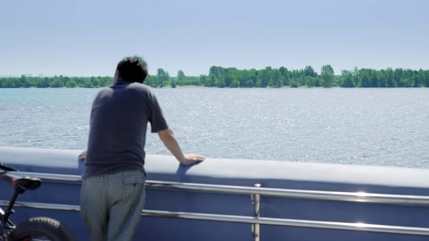 A person gazes thoughtfully into the calm waters, capturing a tranquil moment of deep reflection and peace. Clip