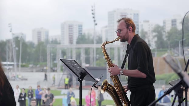 Georgia, Tbilisi - July 20, 2024: A highly talented saxophonist skillfully captivates the audience while performing during a vibrant live outdoor concert. Clip