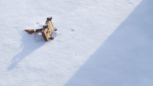 In a serene winter landscape, a piece of wood rests in the snow as a person contemplates the beauty, reflecting on natures tranquility