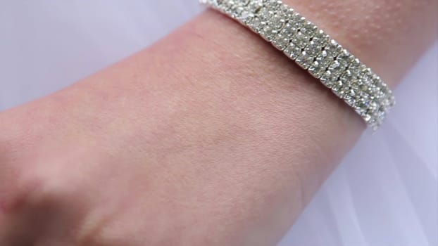 A closeup view of a wrist that beautifully showcases a shimmering bracelet set against smooth skin