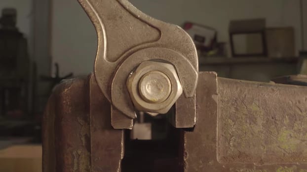This video shows how to use a wrench for metal tasks, starting with removing a nut from a bolt, then tightening another in a vise, and ending with a closeup of a metal object