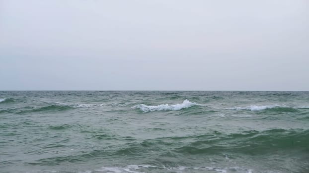 A wonderfully serene view of the ocean waves gently merging with a soft gray sky, evoking deep tranquility and peace