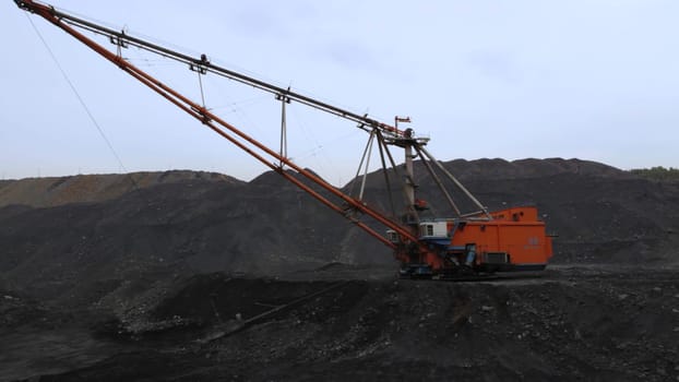 A robust and powerful excavator operates efficiently in a coal mining area, showcasing advanced industrial machinery. Stock Clip