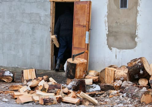Old ax and a deck for chopping wood. Dry firewood, chopped wood for winter heating of the fireplace.