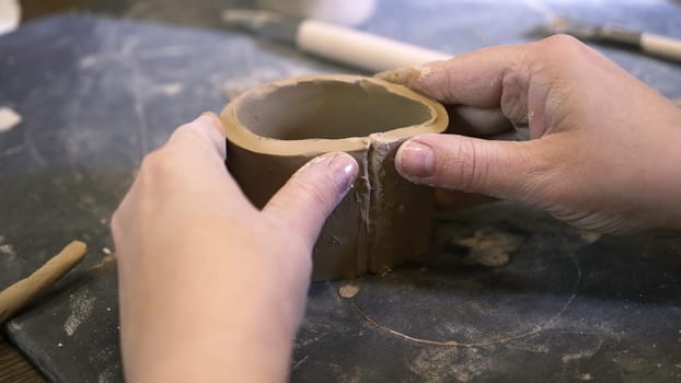Close up of hands shaping clay into a round pot in a pottery studio, highlighting creativity and artistry. Stock Clip