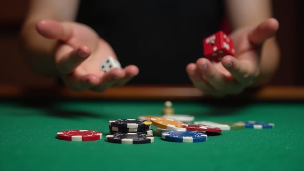 A player focuses intently on the dice in hand, surrounded by a colorful array of poker chips on a green felt table. The atmosphere is vibrant and alive with anticipation for the game.