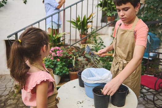 Two children engage in gardening, planting in pots on a sunny day. A sense of teamwork, nature, and learning permeates the scene as they enjoy outdoor activities.
