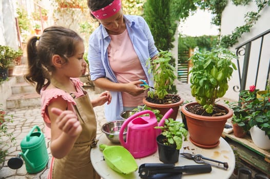 A mother and daughter engage in gardening activities, trimming plants and using various tools. The scene captures a bonding moment and love for nature in a vibrant backyard setting.