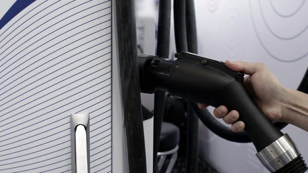 A detailed perspective showcasing the electric vehicle charging equipment along with associated cables. Media