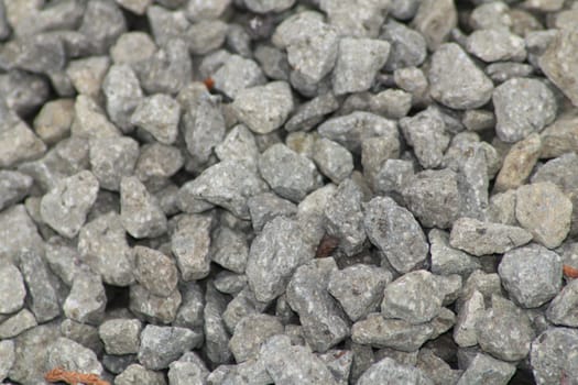Close-up view of gray crushed stone aggregate, showcasing various sizes and shapes of the stones suitable for construction and landscaping applications.