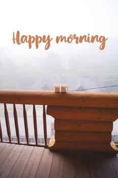 two cups of coffee standing on the balcony on a wooden house-the words of a happy morning.