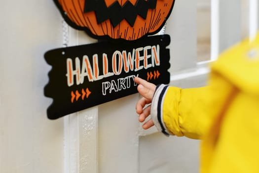 A kid with Carved pumpkin on the fence of the house