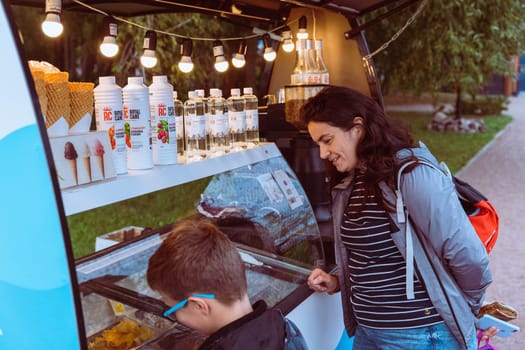KRONSTADT, RUSSIA - SEPTEMBER 23, 2023: mom and son buy fast food in Food Truck in the park
