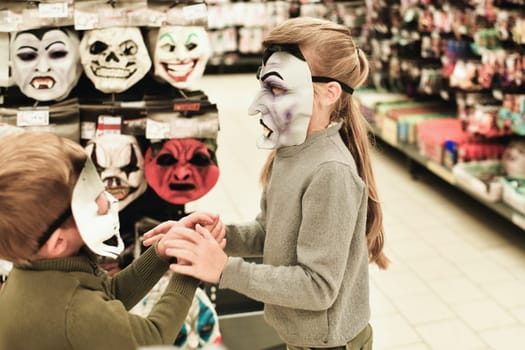 The children chooses the masks at a store for halloween