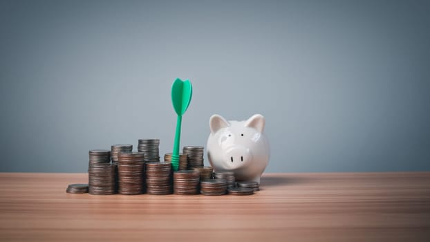 Piggy bank and coins lined up on a wooden background with target icons on a white background. Financial concepts, savings and investments