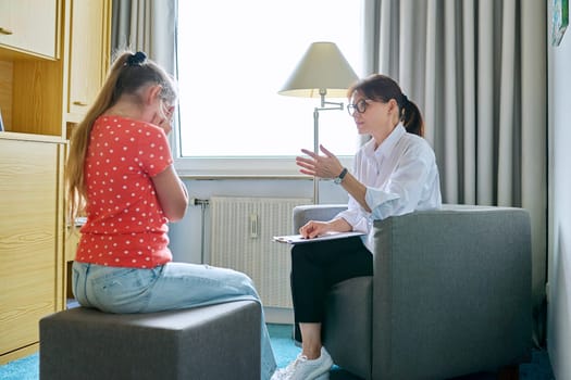 Girl child 10 years old at therapy session with psychologist. School counselor talking to child, listening, helping with problem. Mental health, childhood, schoolchildren, psychology, psychotherapy