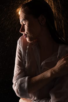 Sexy young woman wearing white shirt shot in shower profile portrait in the dark