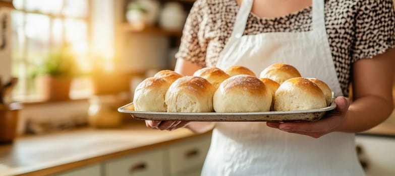 Baker proudly presenting a tray of golden brown, freshly baked buns in a cozy, rustic kitchen