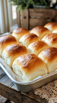 Golden brown dinner rolls resting in a metal baking pan lined with parchment paper, ready to be served