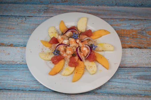 RECIPE CEVICHE OF SHRIMPS AND SCALLOPS WITH CITRUS FRUIT, LEMON, LIME, SQUEEZED ORANGE, GRAPEFRUIT AND FRUIT, PERSIMMON, APPLE, SEASONED WITH ESPELETTE PEPPER. High quality photo