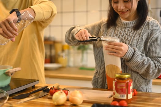 Happy young couple preparing ingredients for a delicious homemade meal during the holidays.
