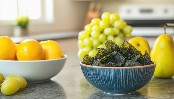 Enjoying a healthy snack of crispy seaweed chips alongside fresh oranges, grapes, and pears in a modern kitchen setting