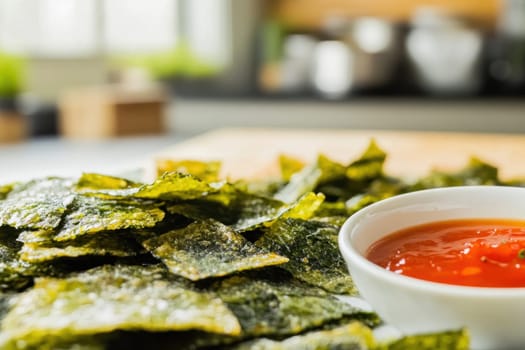 Delicious roasted seaweed chips seasoned with spices and served with a spicy dipping sauce, perfect for a healthy and flavorful snack