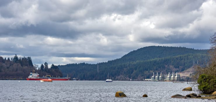 Overview of Pacific Ocean bay near Vancouver with production plant on the shore.