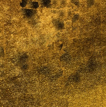 Rough uneven golden surface with dark spots