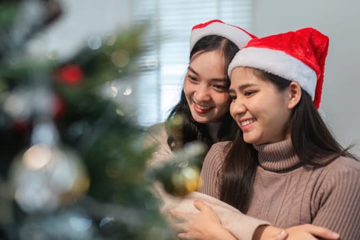 A young couple happily decorates their room for Christmas, embracing the festive spirit with ornaments and holiday cheer.