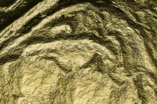 Rough, heavily crumpled golden foil in close-up