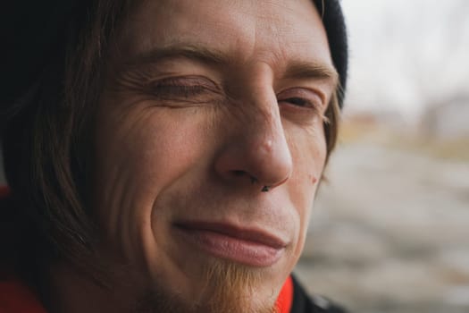 charming individual with a slight squint and mischievous grin captures a joyful moment surrounded by nature.