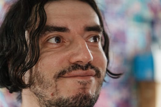 An individual with a friendly expression showcases warmth and enthusiasm, surrounded by colorful artwork