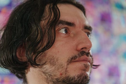 The man gazes with interest, his tousled hair framing a thoughtful face.