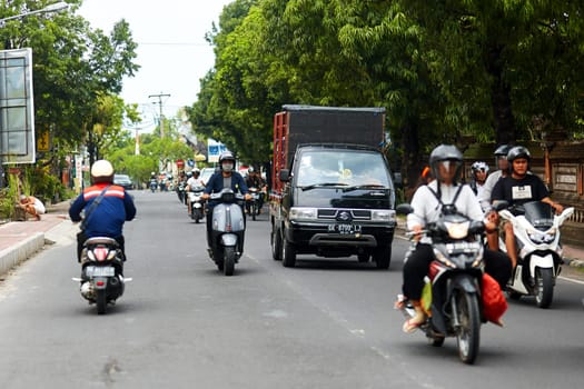 A person on a motorcycle rides a scenic asphalt road in Asia. Bali, Indonesia - 01.03.2018