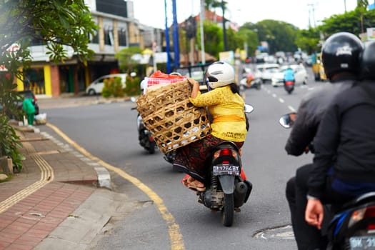 A person on a motorcycle rides a scenic asphalt road in Asia. Bali, Indonesia - 01.03.2018