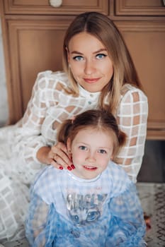 Little girl and her mom on Christmas morning at home. Girl is sad about something and mother is hugging her