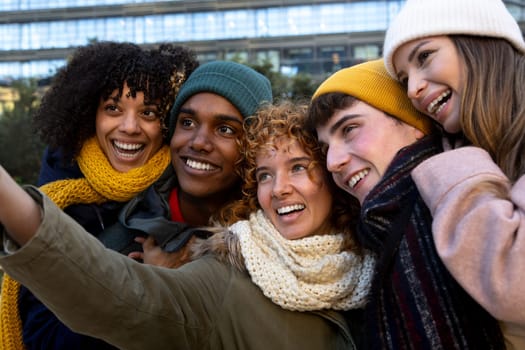 Happy multiracial young friends taking selfie together in the city. Technology and lifestyle concept.
