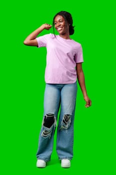 Joyful woman celebrating success with clenched fists against a bright green background close up