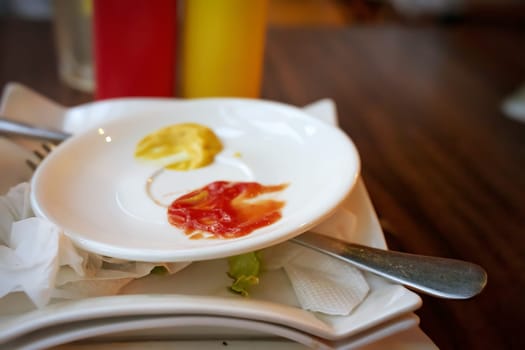 Closeup of vibrant ketchup and mustard on a small plate, perfect for diner and foodrelated themes